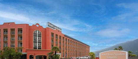 A large red building with a sign reading "Hotel Las Águilas Tenerife".