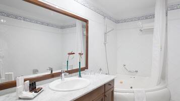 Ein Badezimmer mit zwei Waschbecken, einem großen Spiegel, einer Badewanne und einer Dusche.