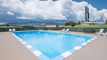 Una piscina al aire libre, sillones reclinables de piscina