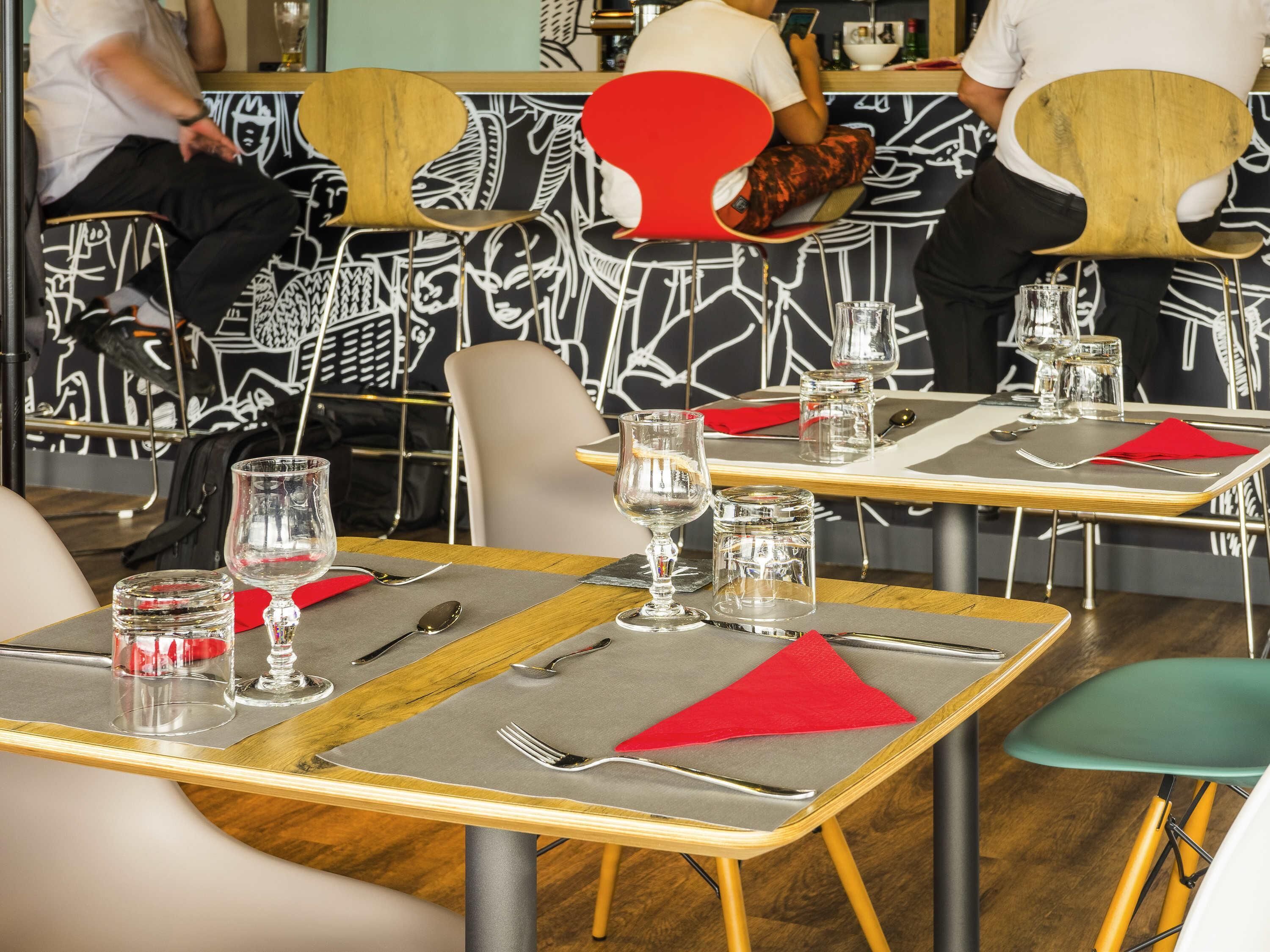 A restaurant interior with tables set for dining, chairs, and a counter area.