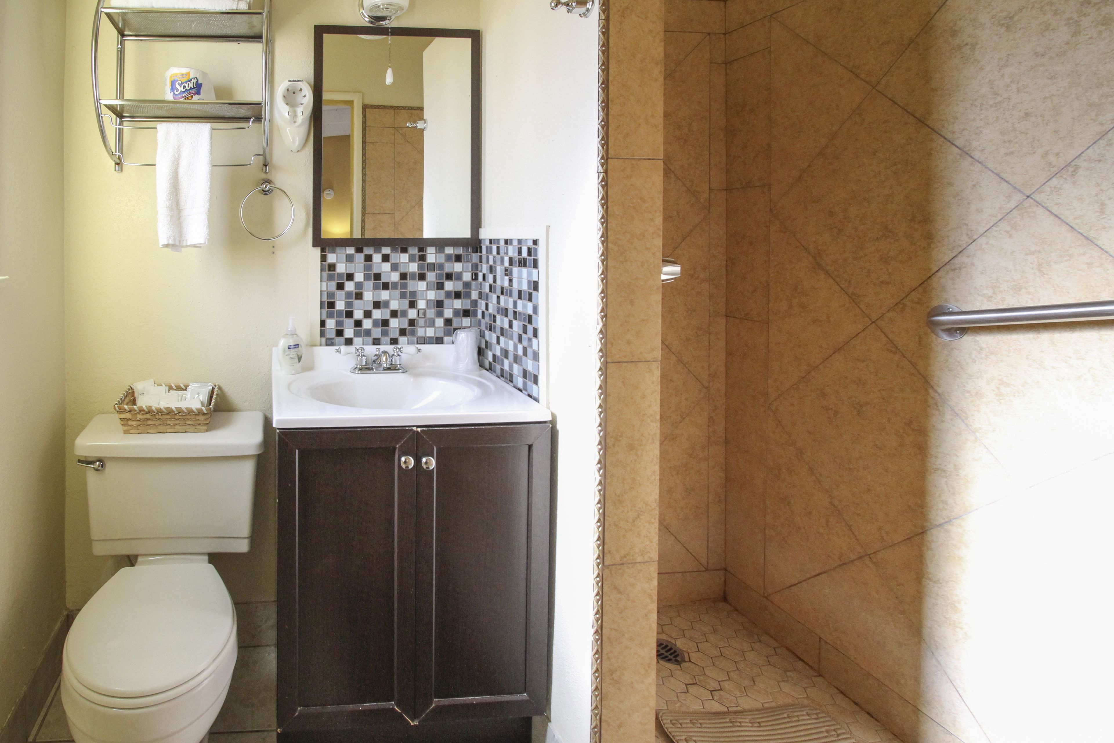 Ein Badezimmer mit Toilette, Waschbecken und Duschbereich.