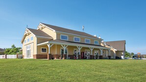 A two-story building with a covered porch and a brick foundation. - Club Wyndham Governor’s Green (Williamsburg)
