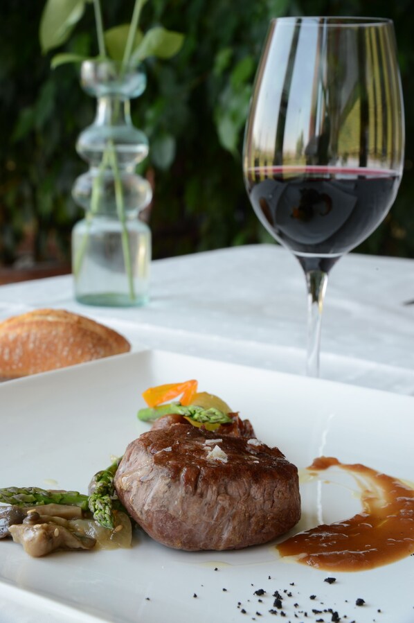 A plate with a steak, asparagus, and a glass of red wine.