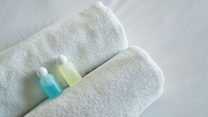 A white towel with two bottles on it. - California Suites Motel (Calexico)