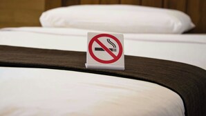 A bed with a no-smoking sign on the headboard. - California Suites Motel (Calexico)