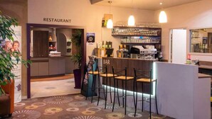 A restaurant with a bar area, bar stools, and a counter.