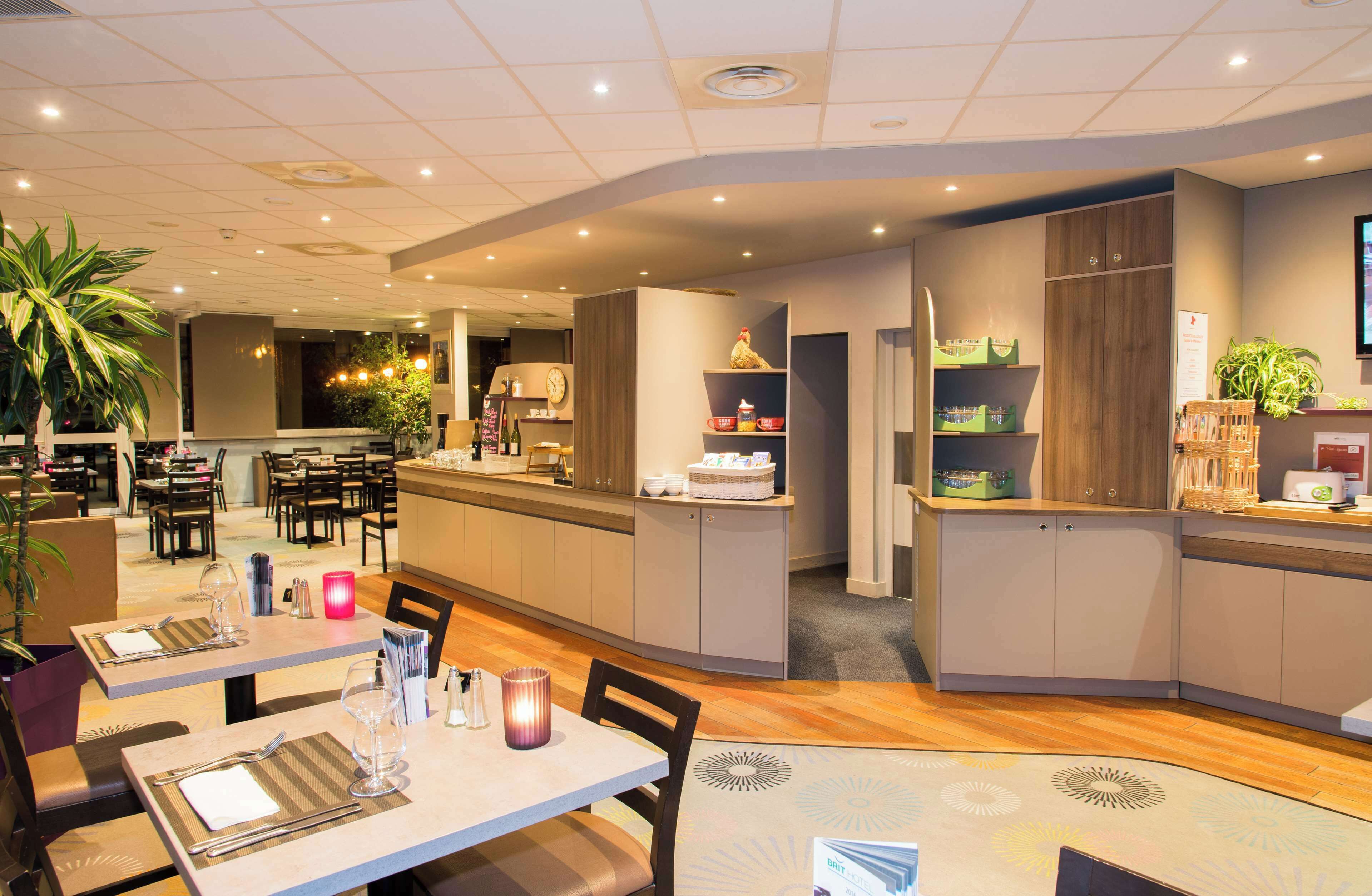 A modern restaurant with a central bar area, multiple dining tables, and a variety of seating options.