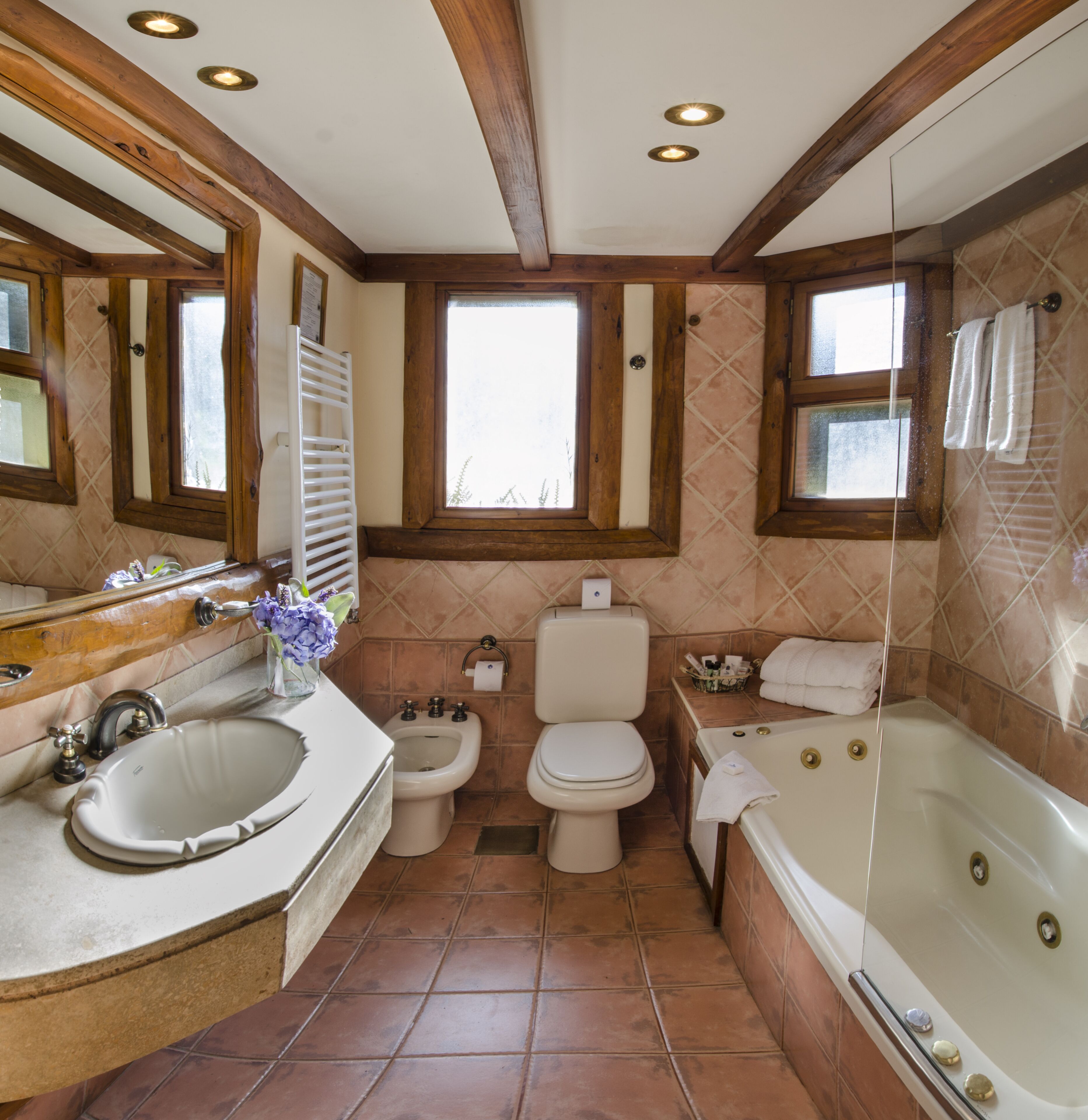A bathroom with a sink, toilet, bidet, and bathtub.