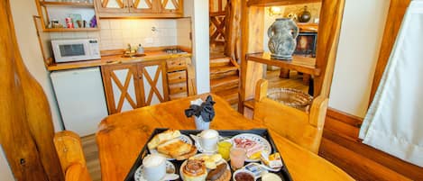 Una mesa de madera con una bandeja de alimentos para el desayuno, como pasteles, café y jugo.