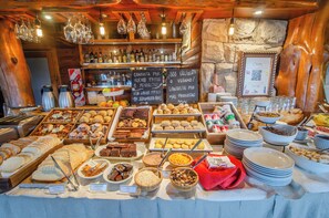 A buffet with various food items, a bar area with bottles, and a chalkboard menu. - Nido del Condor Hotel & Spa (San Carlos de Bariloche)
