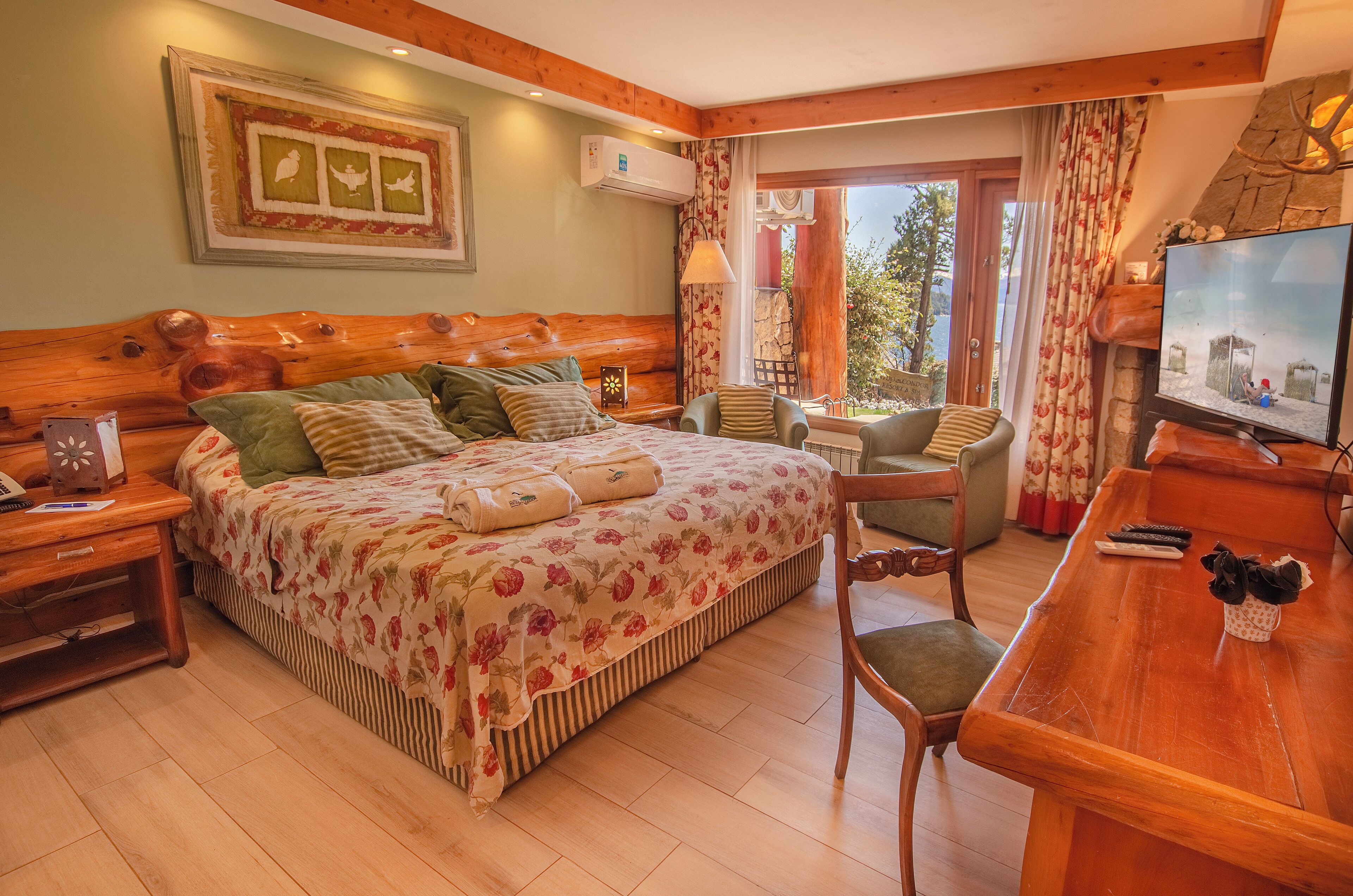 A cozy room with a wooden bed, a television, and a dining area.