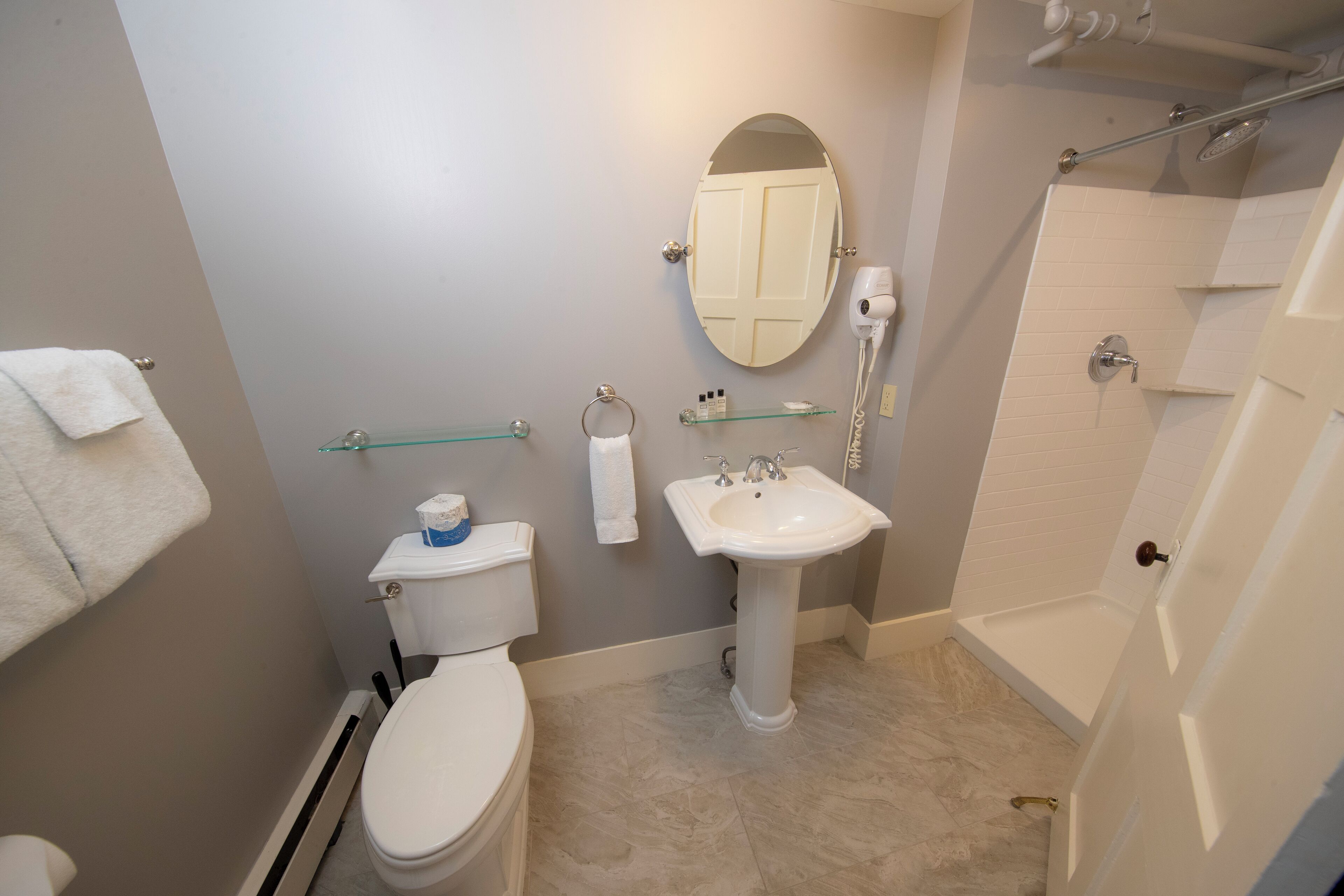 Une salle de bain équipée de toilettes, d’un lavabo, d’un miroir et d’une douche.