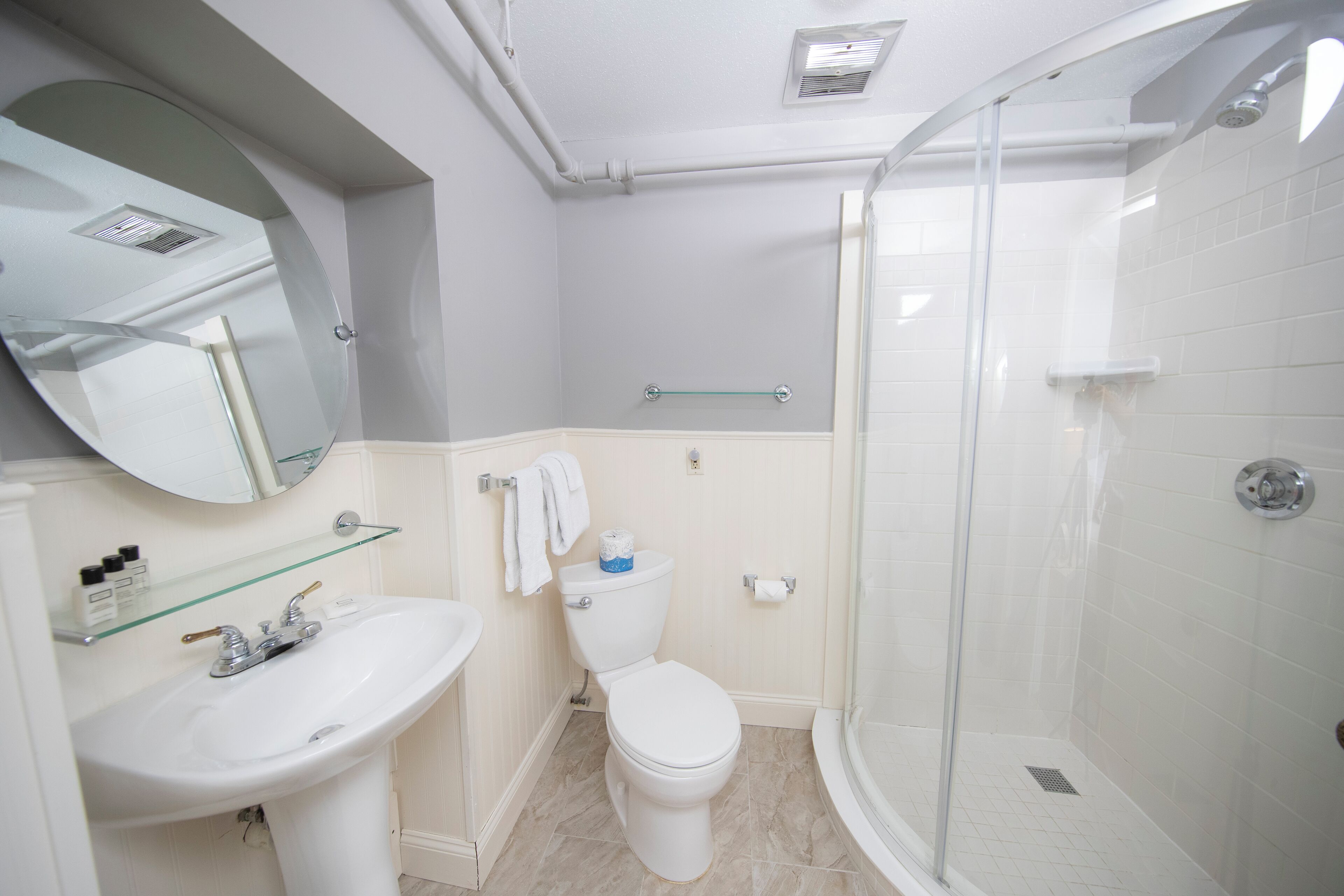 Une salle de bain moderne avec un lavabo, des toilettes et une douche à parois de verre.