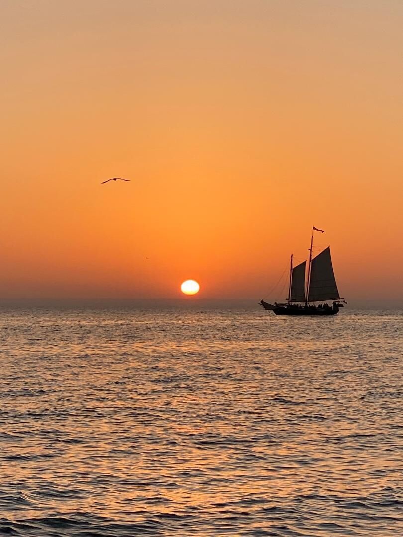 Un velero en aguas tranquilas al atardecer.