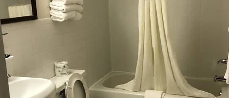 A bathroom with a toilet, sink, and bathtub.