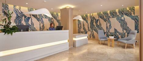 Una moderna zona de recepción con mostrador, asientos y diseños de pared estampados.