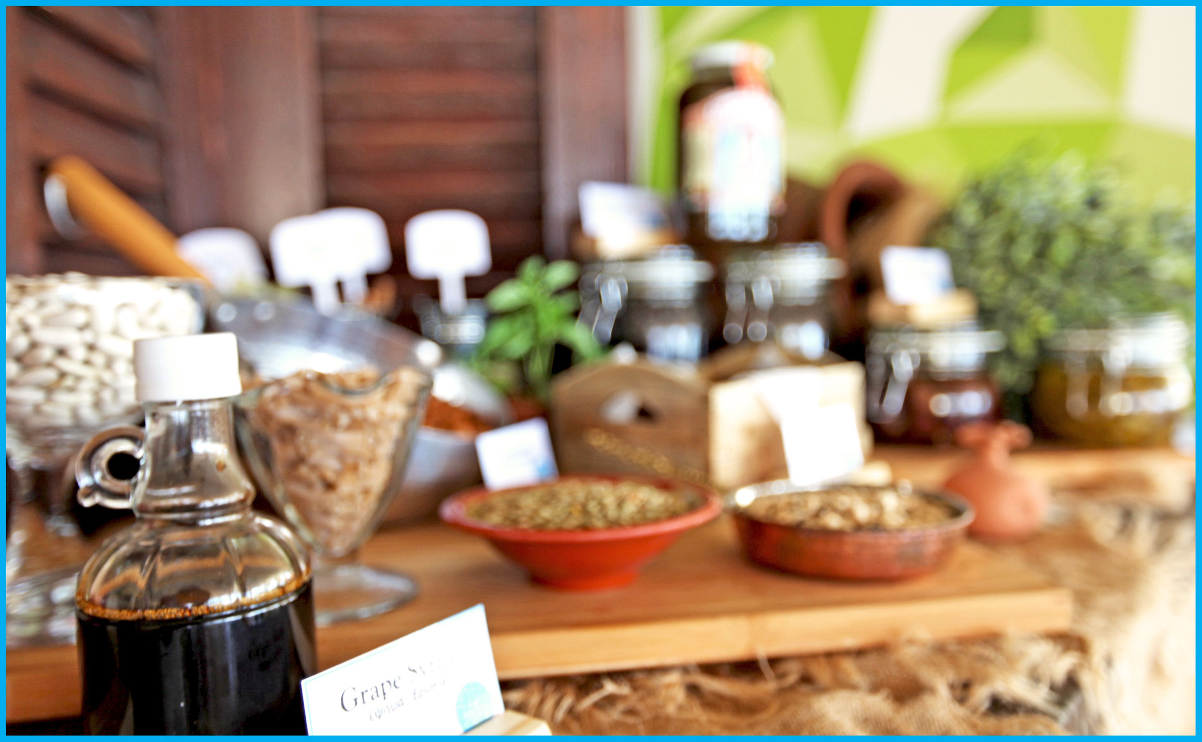 A variety of jars and containers on a wooden table, likely containing food items or condiments.