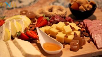 A variety of cheeses, fruits, and nuts on a wooden board.