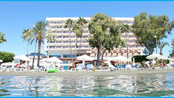 Di pantai, kursi berjemur, handuk pantai, dan bar pantai