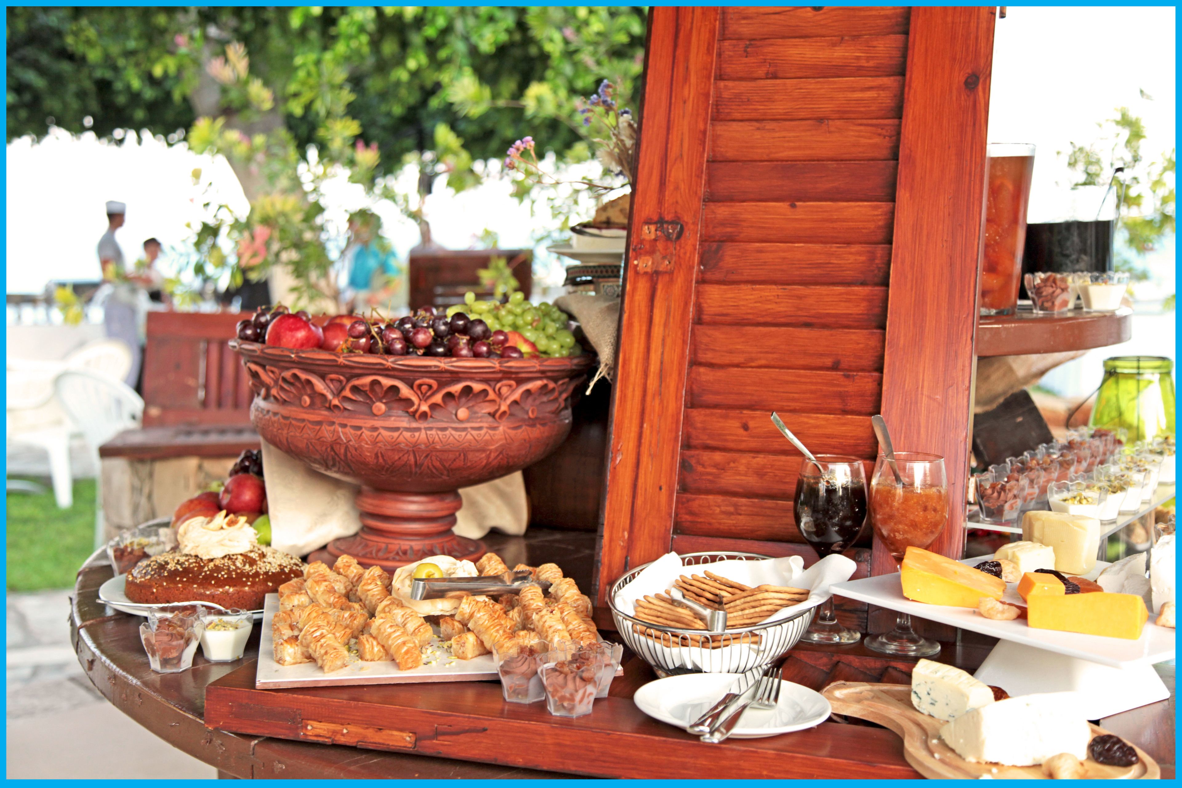 A buffet table with various food items and a large decorative bowl.