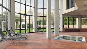 A spacious indoor area with large windows, a hot tub, and several lounge chairs. - Protur Turó Pins Hotel (Capdepera)
