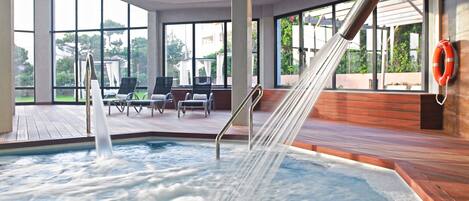 A hot tub with water jets, wooden deck, and outdoor seating area with chairs.