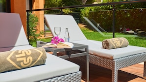 A balcony with two lounge chairs, a small table, and a book. - Protur Turó Pins Hotel (Capdepera)