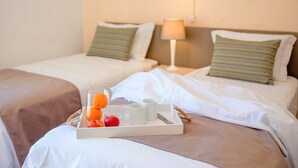 A hotel room with two beds, a tray with breakfast items, and artwork on the walls. - Turial Old Town Ocean View (Albufeira)