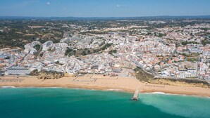 An aerial view of a coastal city with a beach, buildings, and a pier. - Turial Old Town Ocean View (Albufeira)