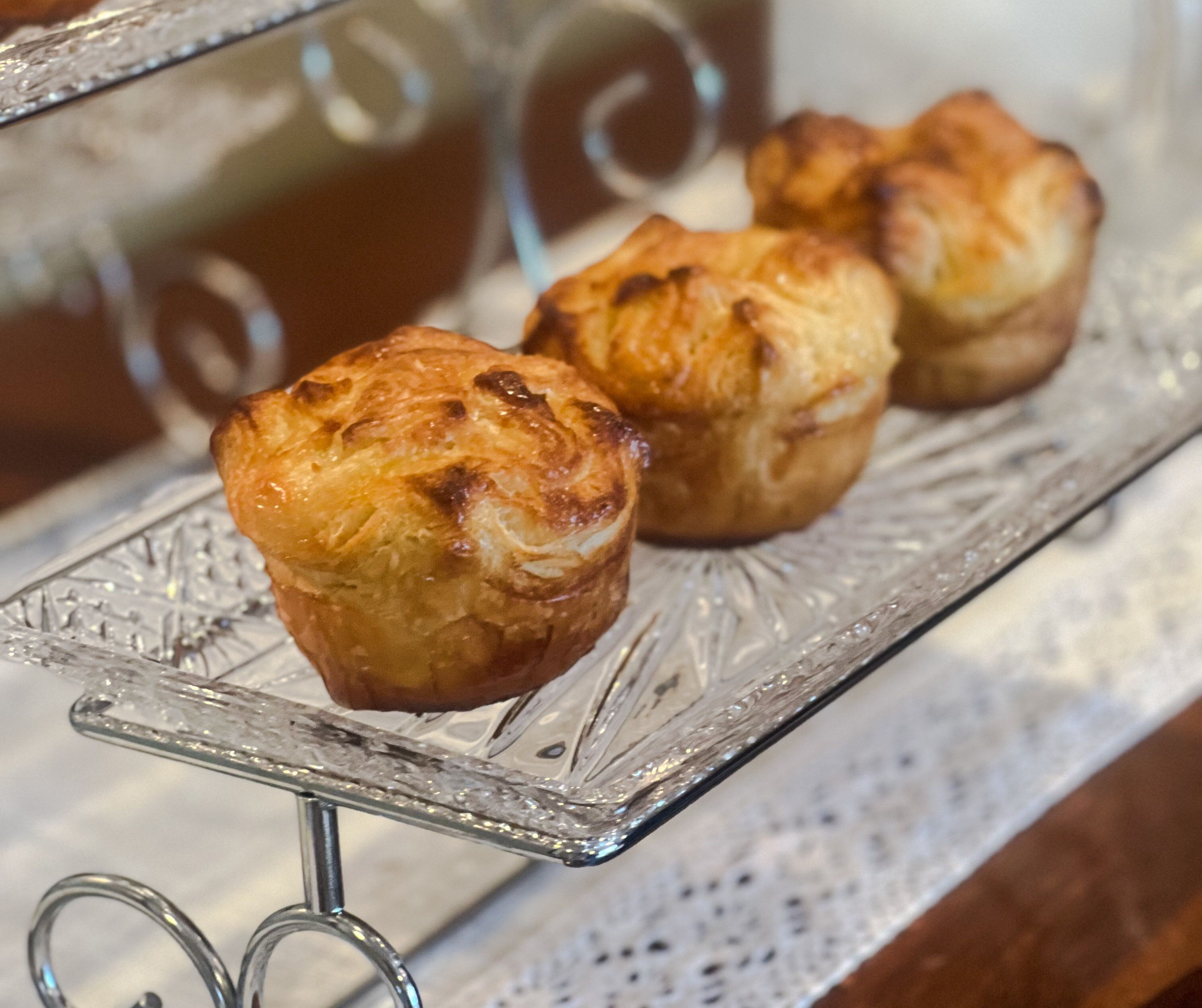 A glass display case with three pastries on a metal stand.