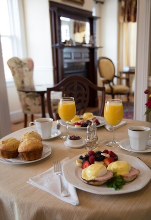 A breakfast table with muffins, fruit, and coffee. - Almondy Inn (Newport)