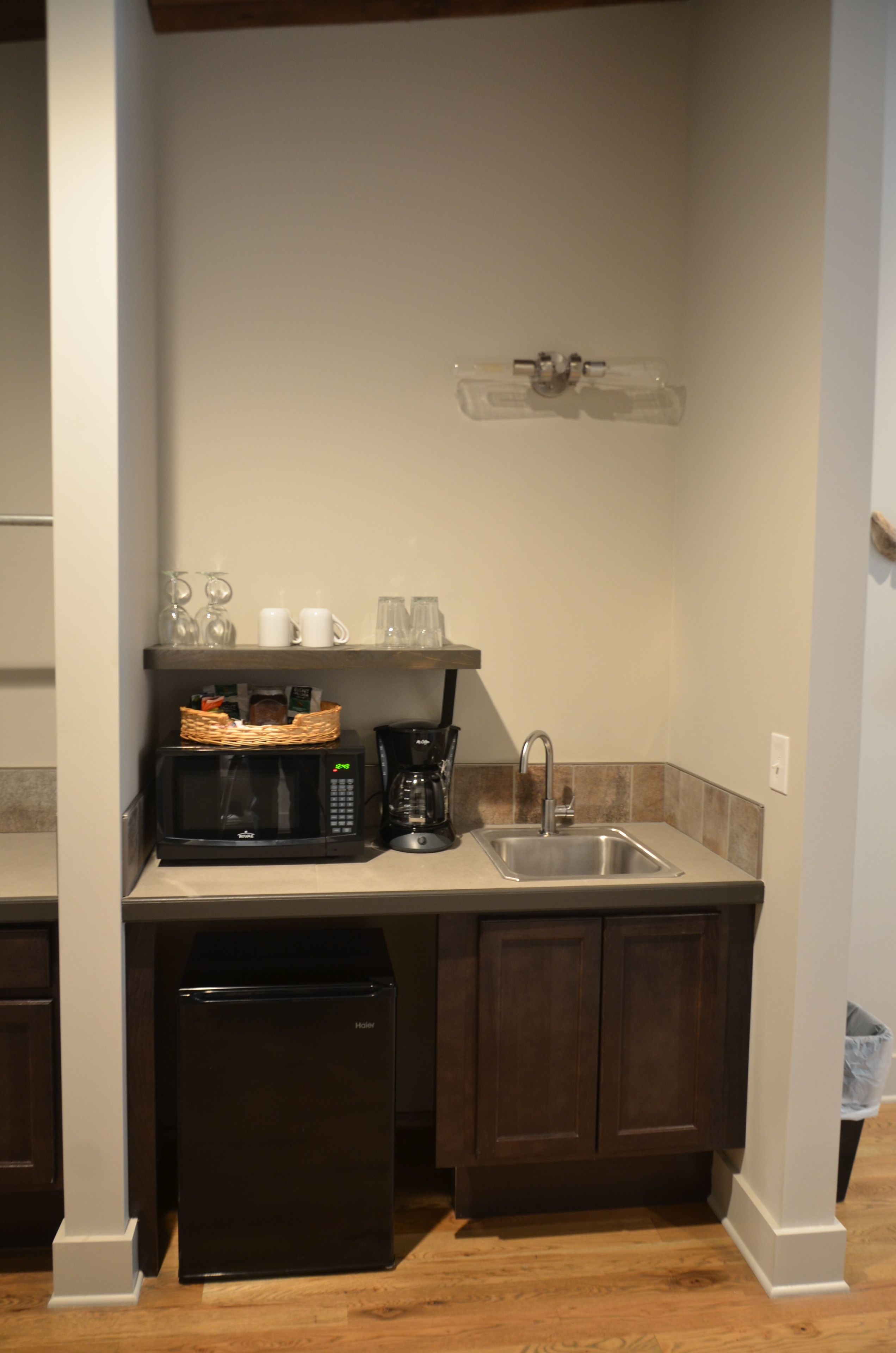 Cocina compacta con microondas, cafetera y refrigerador.