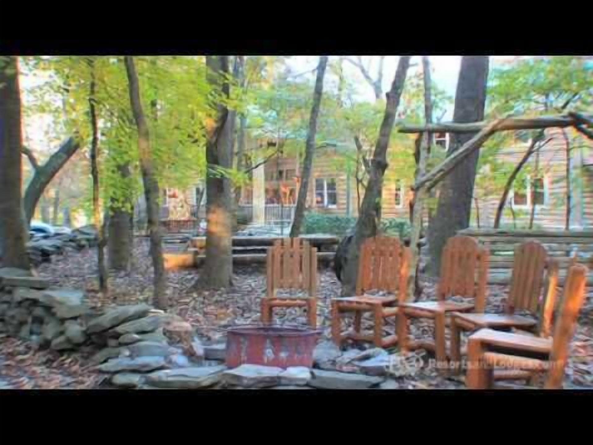 Un espace extérieur aménagé dans un style rustique, avec des chaises en bois et un foyer en pierre.