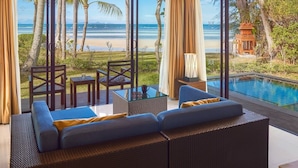 A modern outdoor seating area with a view of the ocean, a pool, and a traditional wooden structure. - TUI BLUE The Passage Samui Pool Villas with Private Beach Resort (Koh Samui)