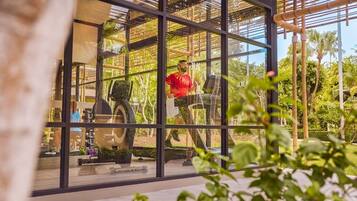 Gimnasio con equipamiento de ejercicio y una persona con una camiseta roja.
