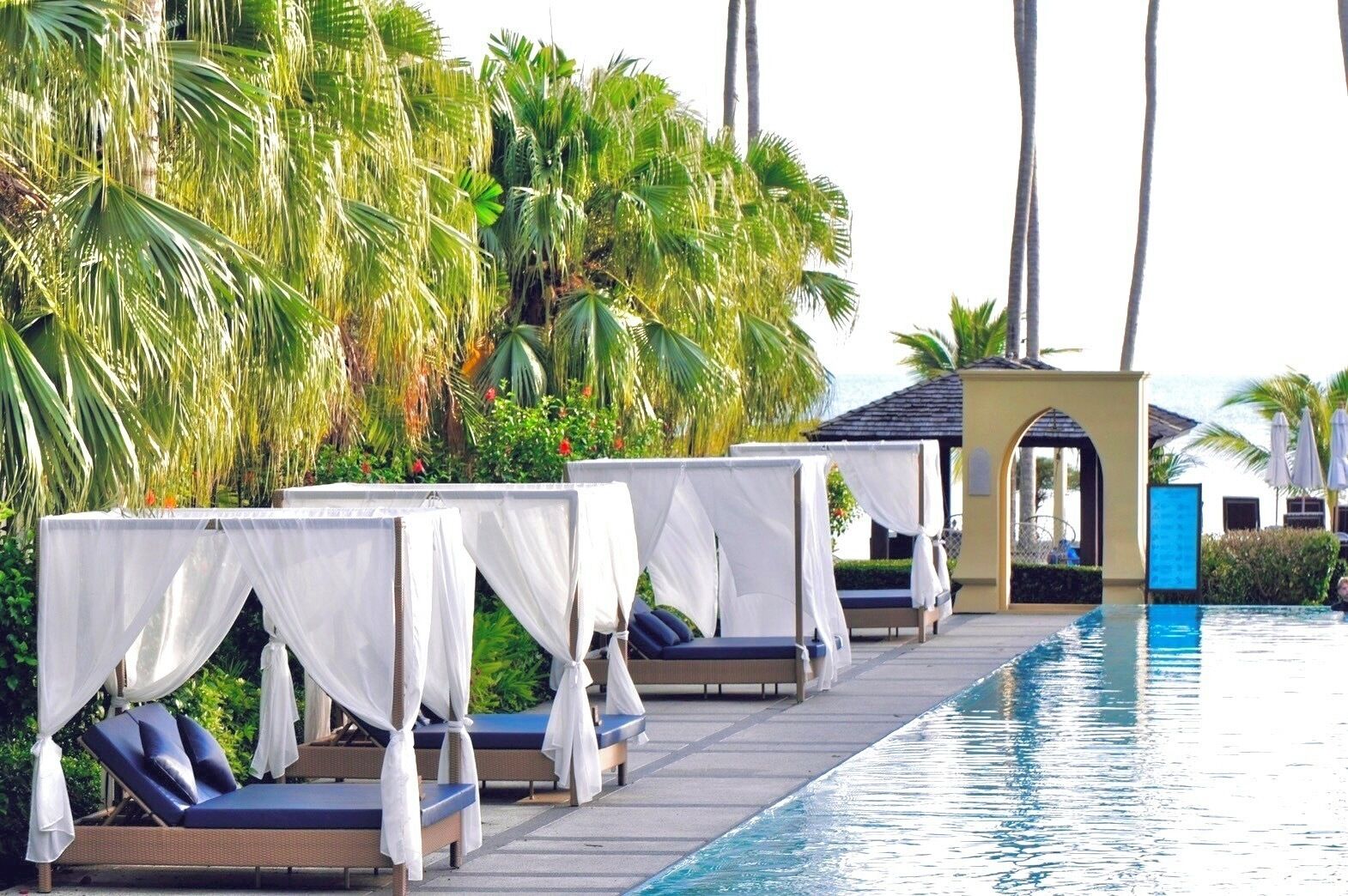 A poolside area with lounge chairs and a small pavilion.