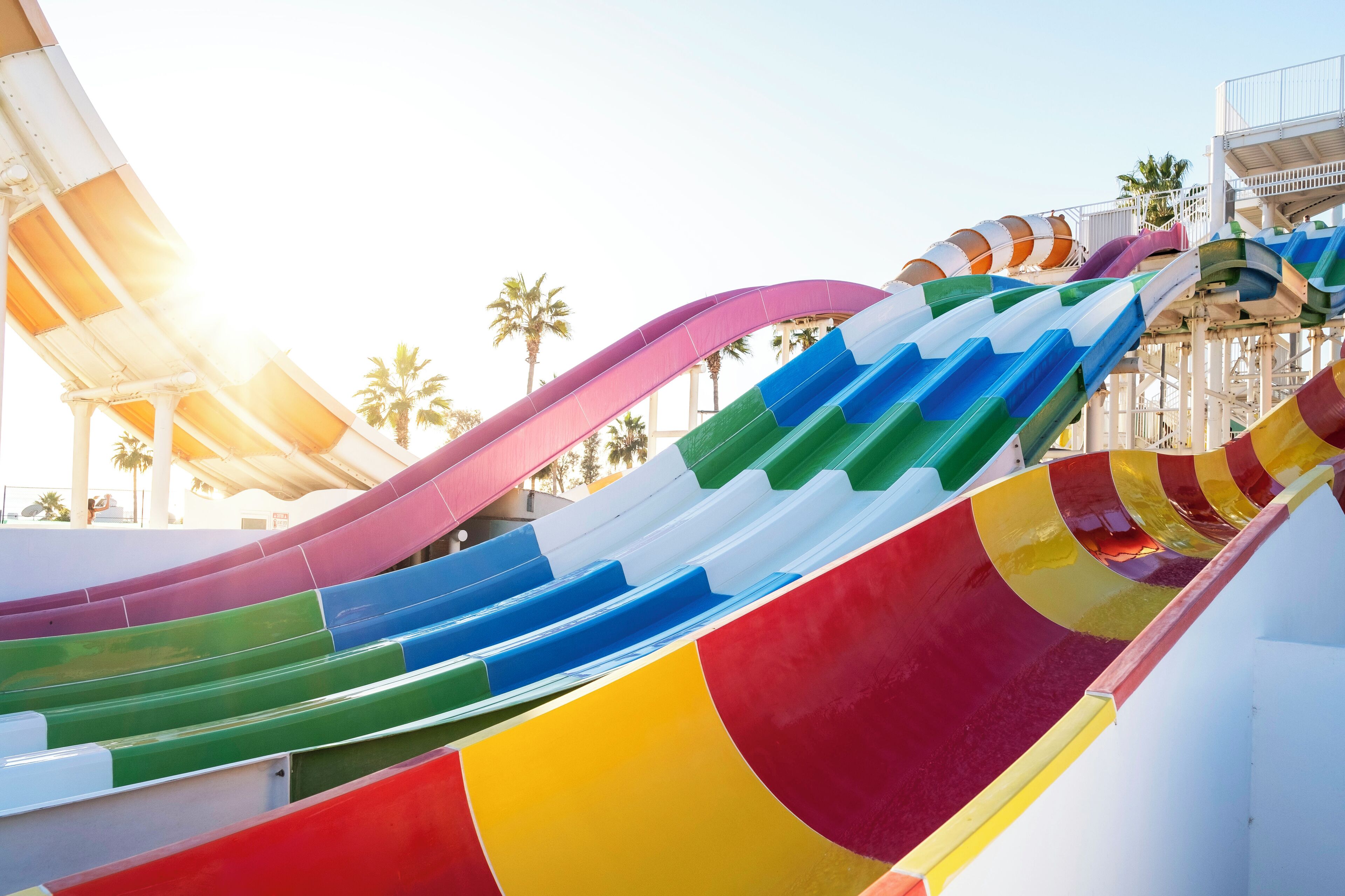 A multi-colored water slide with a white structure in the background.