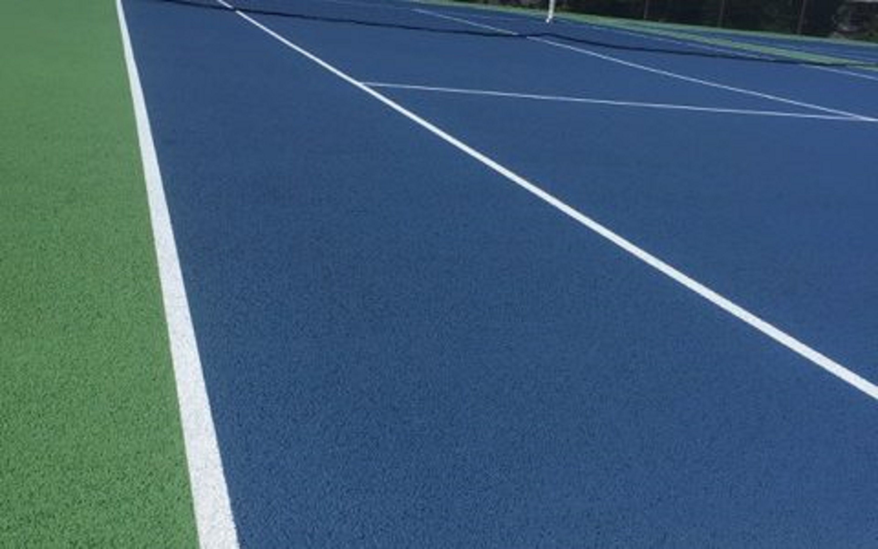 Uma quadra de tênis com superfície azul e linhas de demarcação brancas.