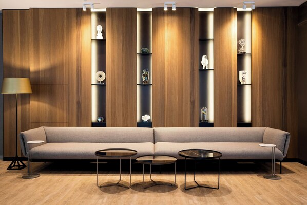 A modern living room with a sofa, three round tables, and a floor lamp. - AC Hotel by Marriott Riga (Riga)