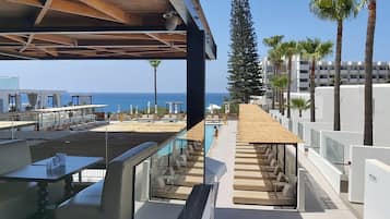 Una piscina techada, una piscina al aire libre, sombrillas