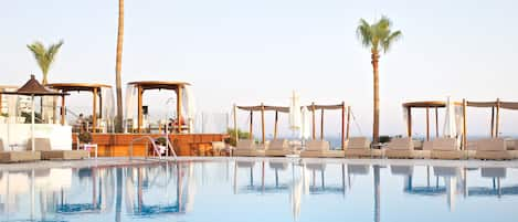 Piscine couverte, piscine extérieure, parasols de plage, chaises longues