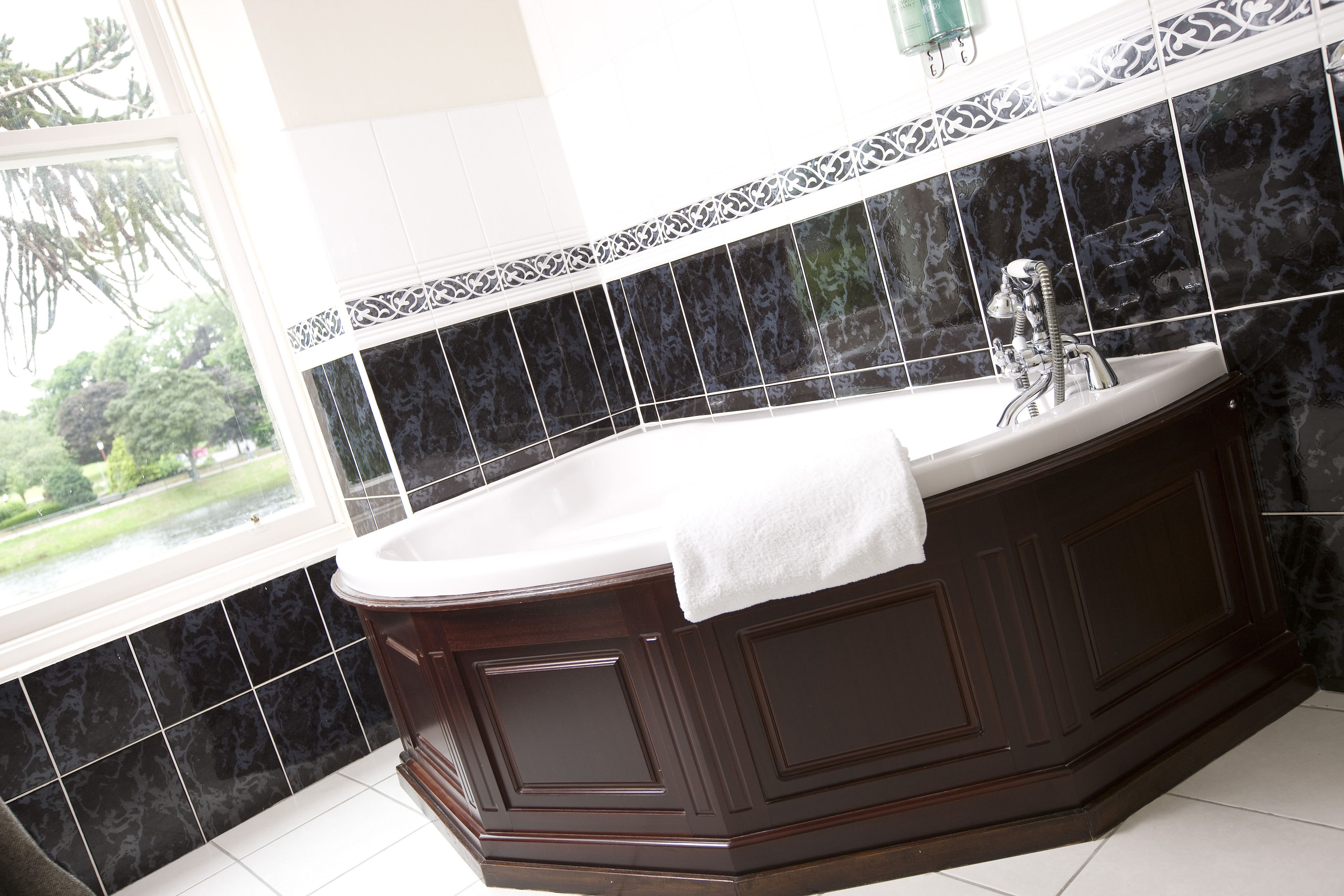 deluxe king room | bathroom | combined shower/bathtub, designer toiletries, hair dryer, bathrobes