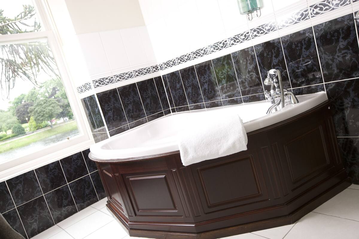 deluxe king room | bathroom | combined shower/bathtub, designer toiletries, hair dryer, bathrobes