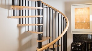 A spiral staircase with wooden steps and black metal railings.