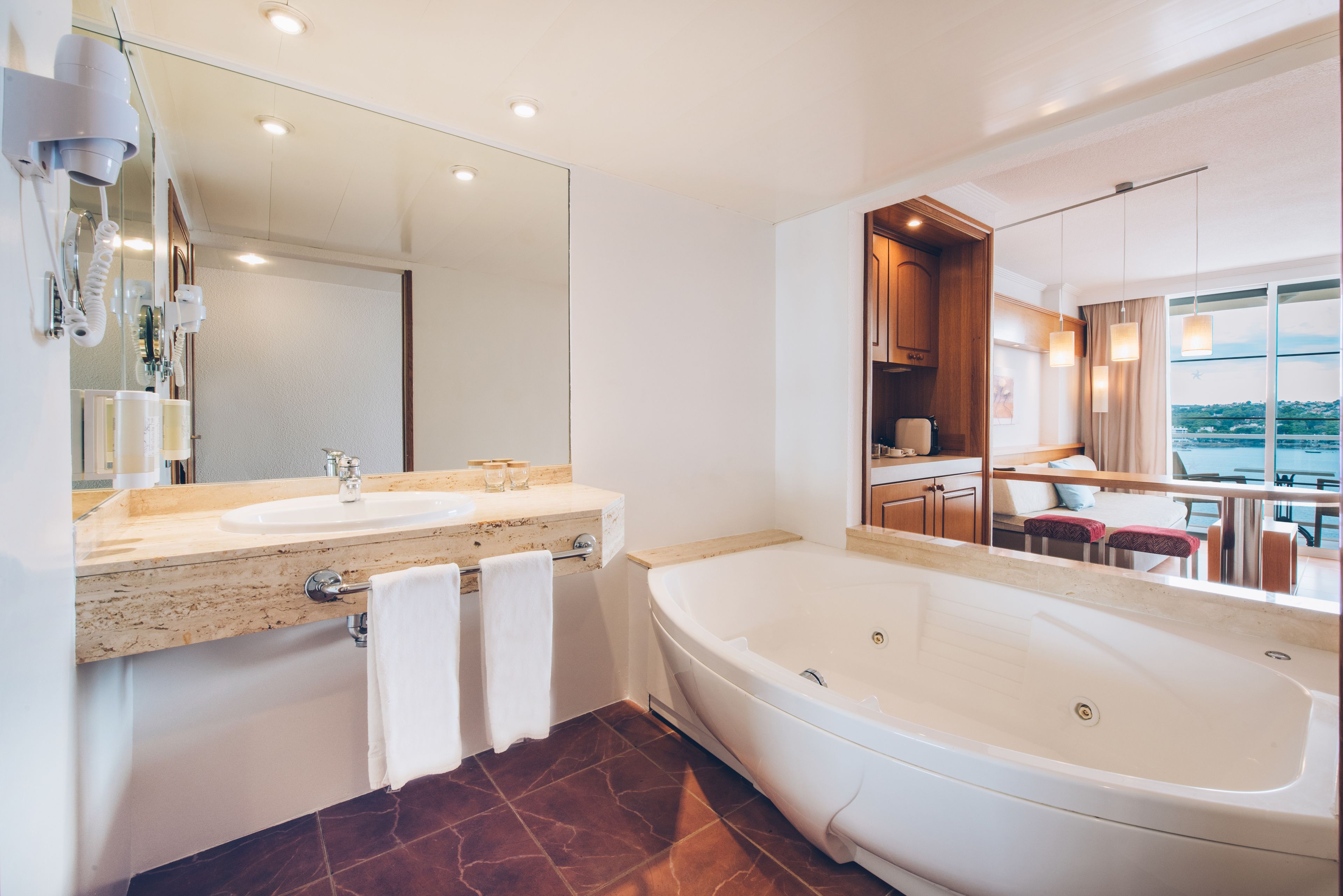 Ein modernes Badezimmer mit einer großzügigen Badewanne, einem Doppelwaschtisch und einem großen Spiegel.