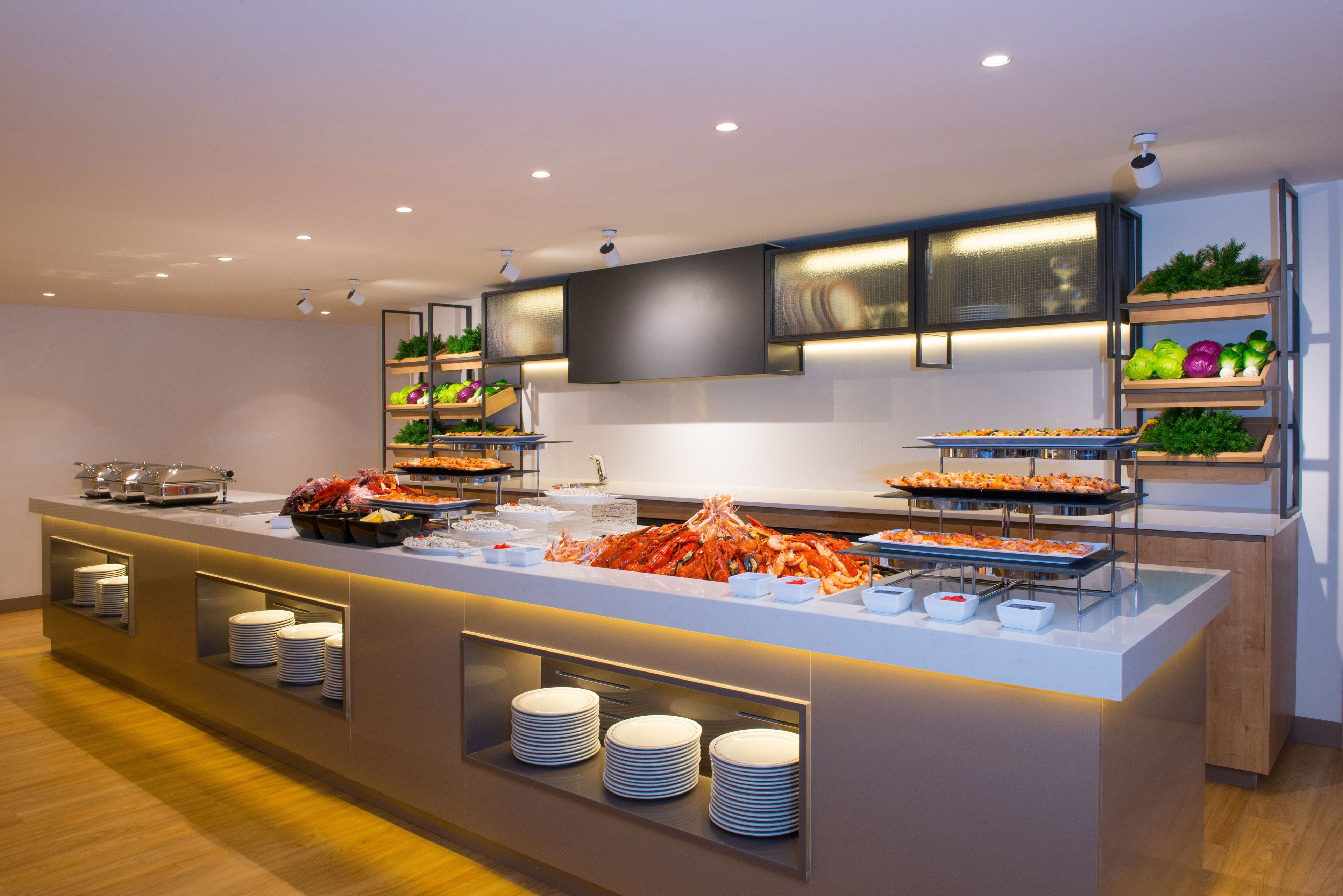 Una presentación de buffet moderna con varias estaciones de comida y una gran variedad de platos.