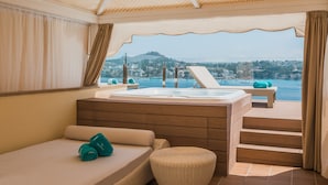 A balcony with a hot tub, a bed, and a view of the sea. - Iberostar Selection Jardín del Sol Suites - Adults Only (Calvia)
