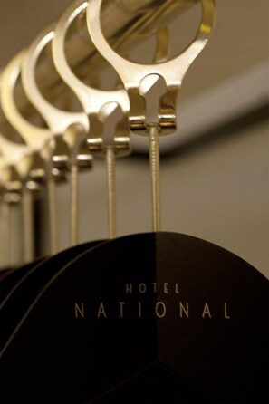 A close-up of a metallic, circular object with the text "HOTEL NATIONAL" visible on a dark surface. - Hotel National (Antwerp)
