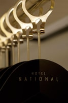 Primer plano de un objeto metálico y circular con la leyenda “HOTEL NATIONAL” visible sobre una superficie oscura.