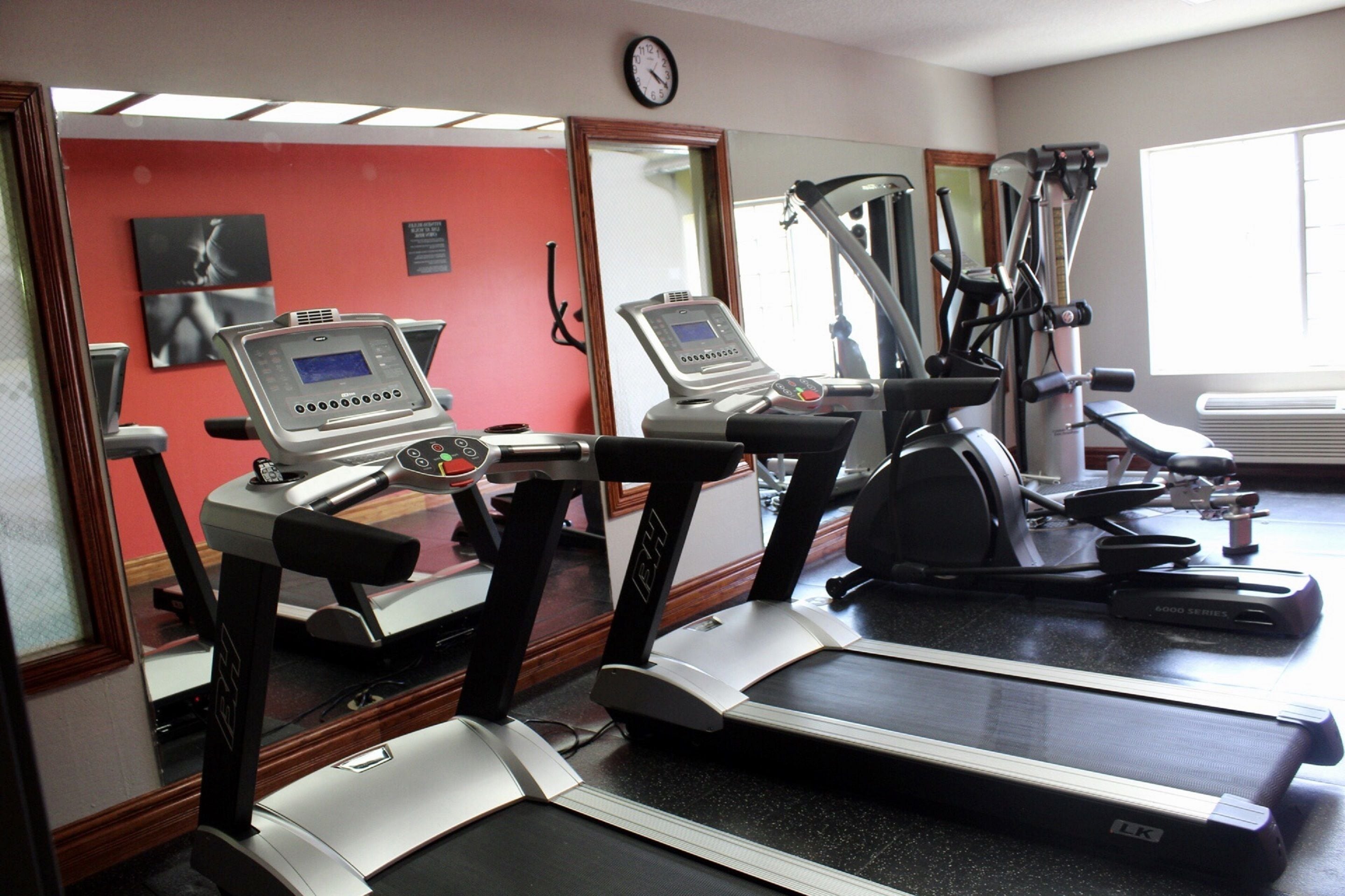 A gym with treadmills, a stationary bike, and a weight machine.